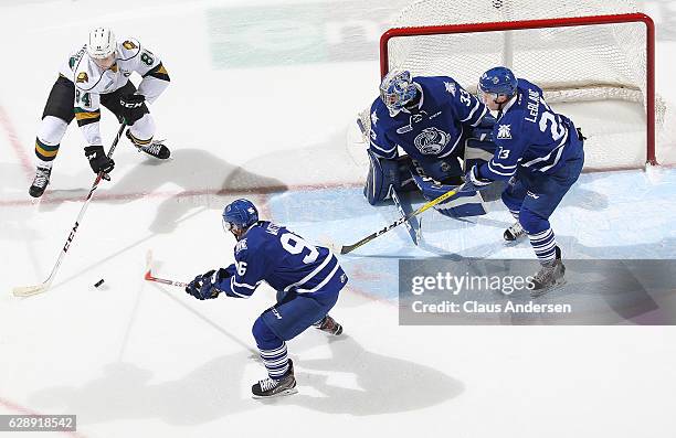 Spencer Watson of the Mississauga Steelheads tries to knock the puck away from JJ Piccinich of the London Knights during an OHL game at Budweiser...