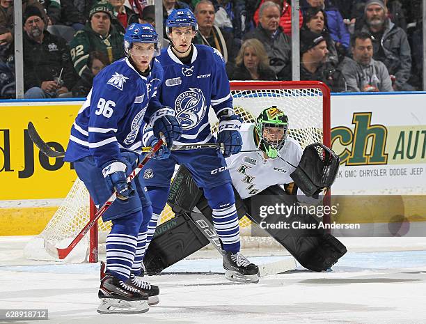 Spencer Watson and Brendan Harrogate of the Mississauga Steelheads both look for a shot to tip in front of Tyler Parsons of the London Knights during...