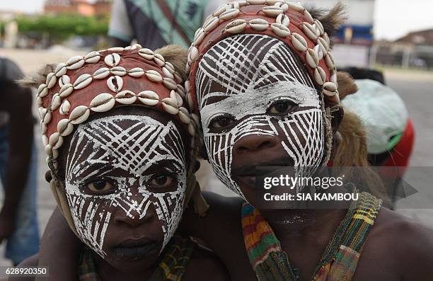 Two child pose on the sideline of their traditional dance performance ahead of an international competition, on December 9, 2016 in Abidjan. / AFP /...