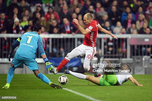 Arjen Robben of Muenchen tries to score against goalkeeper Diego Benaglio and Ricardo Rodriguez of Wolfsburg during the Bundesliga match between...