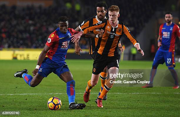 Wilfried Zaha of Crystal Palace holds off Sam Clucas of Hull City as he scores their second goal during the Premier League match between Hull City...
