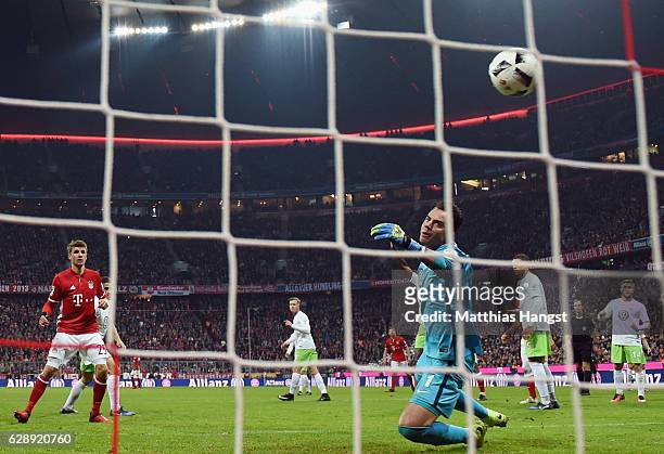 Thomas Mueller of Muenchen scores his team's fourth goal past goalkeeper Diego Benaglio of Wolfsburg during the Bundesliga match between Bayern...