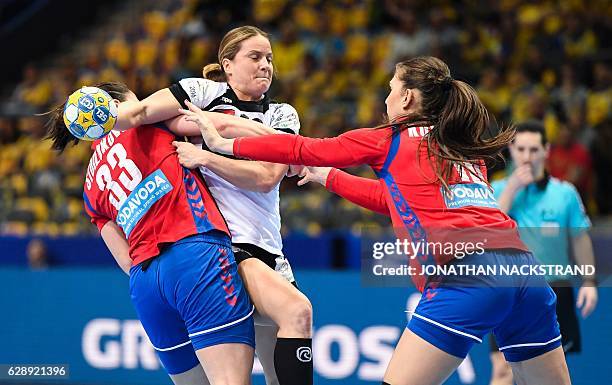 Germany's Anna Loerper vies with Serbia's Jovana Stoiljkovic and Jovana Kovacevic during the Women's European Handball Championship Group I match...