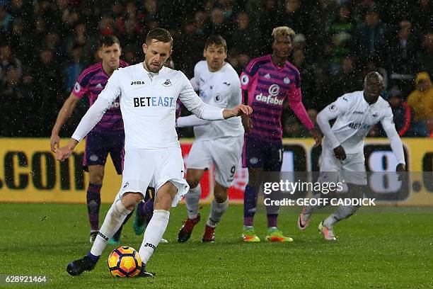 Swansea City's Icelandic midfielder Gylfi Sigurdsson scores the opening goal from the penalty spot during the English Premier League football match...
