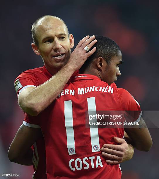 Bayern Munich's Dutch midfielder Arjen Robben embraces Bayern Munich's Brazilian midfielder Douglas Costa after the fifth goal during the German...