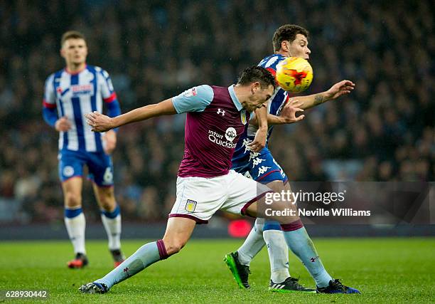 Tommy Elphick of Aston Villa ash challenged by Yanic Wildschut of Wigan Athletic during the Sky Bet Championship match between Aston Villa and Wigan...