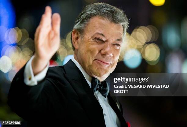 Colombian president and 2016 Nobel Prize for Peace laureate Juan Manuel Santos reacts to the torchlight parade from the balcony of the Grand Hotel in...