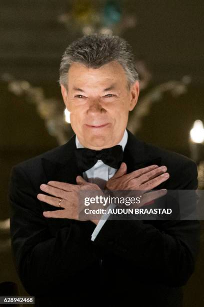 Colombian president and 2016 Nobel Prize for Peace laureate Juan Manuel Santos reacts to a torchlight parade from the balcony of the Grand Hotel in...