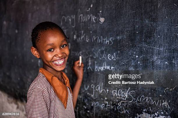 african little girl is learning english language, orphanage in kenya - child standing stock pictures, royalty-free photos & images
