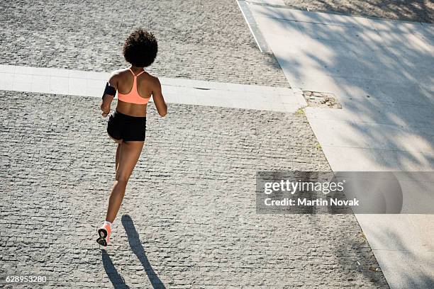 rear shot of a female athlete runner in action - blickwinkel vom autorücksitz stock-fotos und bilder