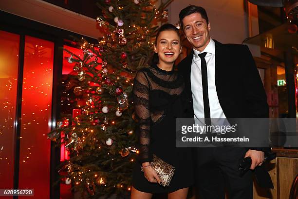 Robert Lewandowski of FC Bayern Muenchen poses with his wife Anna Stachurska as they arrive for the club's Christmas party at H'ugo's bar on December...