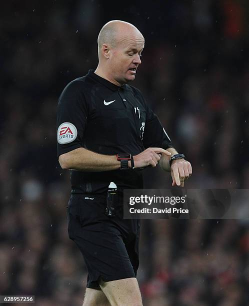 Referee Lee Mason points to his watch during the Premier League match between Arsenal and Stoke City at Emirates Stadium on December 10, 2016 in...