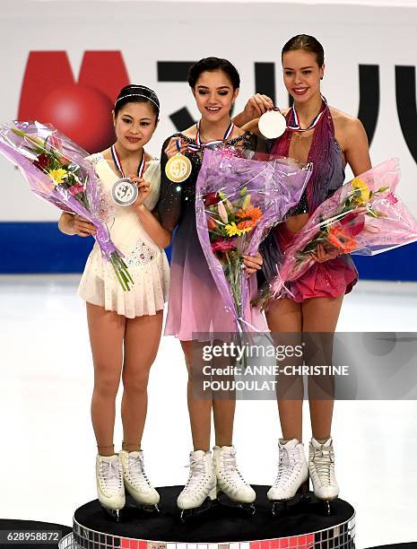 First placed Russian Evgenia Medvedeva , second placed Japan's Satoko Miyahara and third placed Russian Anna Pogorilaya , pose on the podium with...