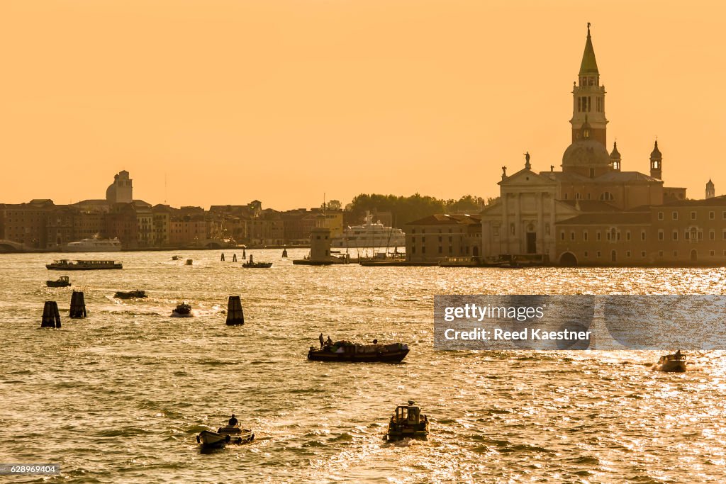 Boats on the Grand Canal during a golden sunset in Venice, Italy