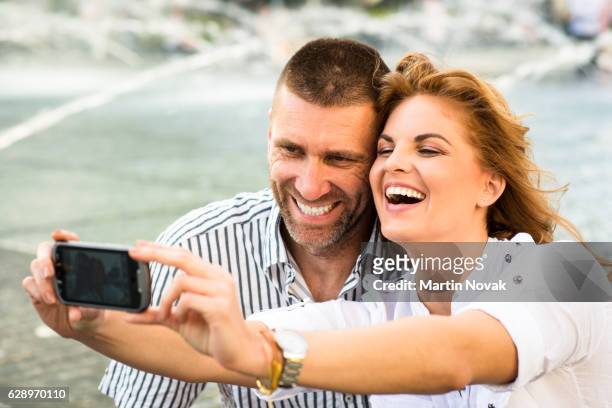couple taking selfie by mobile phone - groupie stock-fotos und bilder