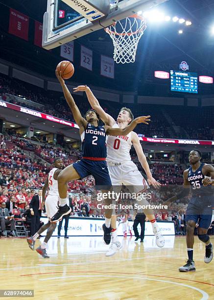 Connecticut Huskies guard Jalen Adams attempts a lay up while Ohio State Buckeyes center Micah Potter guards him during the first half at the Value...