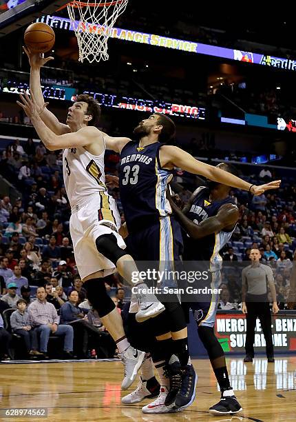 Omer Asik of the New Orleans Pelicans shoot the ball over Marc Gasol of the Memphis Grizzlies during a game at the Smoothie King Center on December...