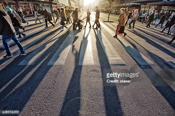 pedestrians in silhouette, sunset in stockholm - stockholm stock pictures, royalty-free photos & images
