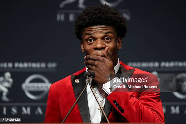 Lamar Jackson of the Louisville Cardinals reacts as he addresses the media after being named the 82nd Heisman Memorial Trophy Award winner during the...