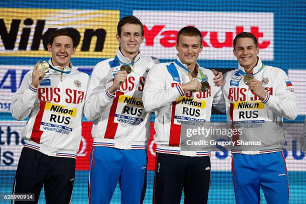 Team Russia celebrates their gold medal in the 4x50m Medley on day five of the 13th FINA World Swimming Championships at the WFCU Centre on December...