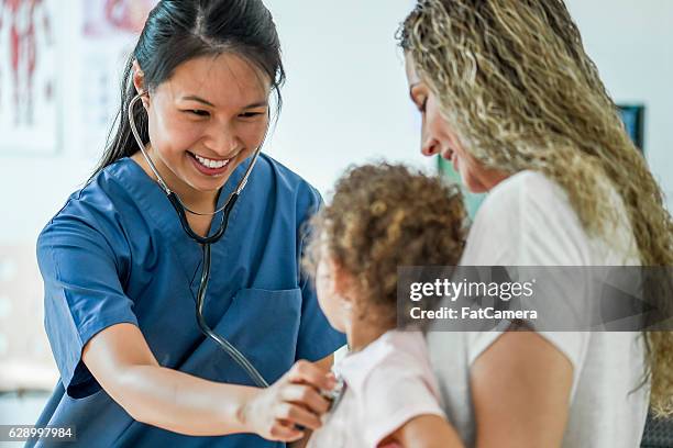 kleines mädchen bei einem check-up - nurse child stock-fotos und bilder