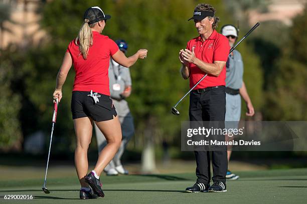 Bernhard Langer of Germany applauds daughter Christina's putt on the 18th green during the first round of the PNC Father/Son Challenge at The...