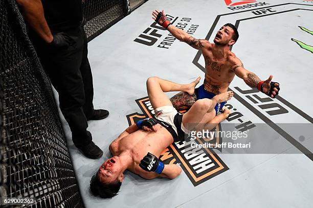 Cub Swanson and Dooho Choi of South Korea react after the conclusion of their three-round featherweight bout during the UFC 206 event inside the Air...