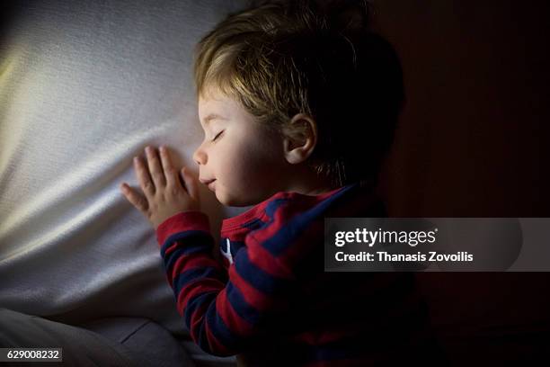 2 year old boy sleeping in a dark room - good night imagens e fotografias de stock