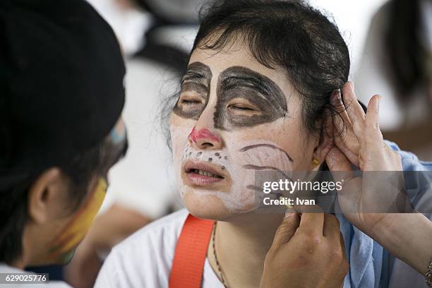 a woman in costume dress at a festival - halloween makeup stock-fotos und bilder