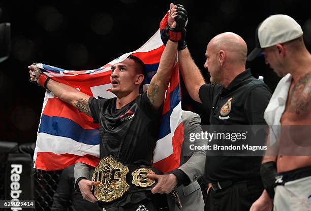 Max Holloway celebrates his victory over Anthony Pettis in their interim UFC featherweight championship bout during the UFC 206 event inside the Air...