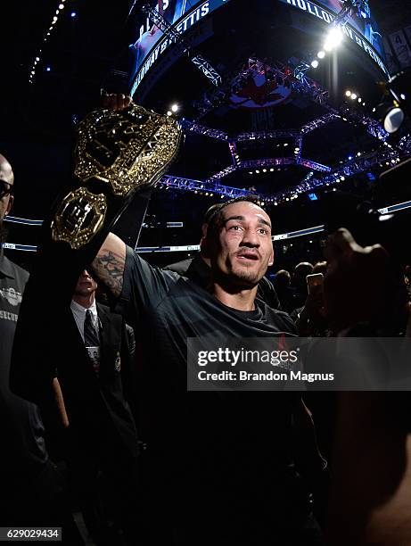 Max Holloway celebrates his victory over Anthony Pettis in their interim UFC featherweight championship bout during the UFC 206 event inside the Air...