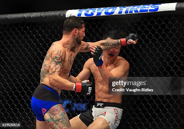 Doo Ho Choi of South Korea fights Cub Swanson of the United States in their Featherweight bout during the UFC 206 event at Air Canada Centre on...