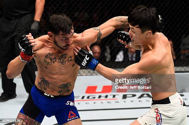 Cub Swanson punches Dooho Choi of South Korea in their featherweight bout during the UFC 206 event inside the Air Canada Centre on December 10, 2016...