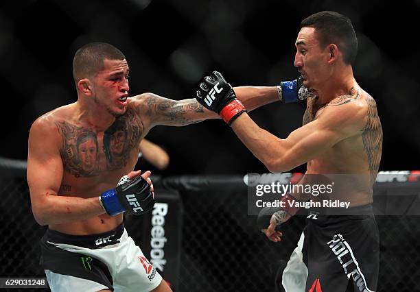 Max Holloway of the United States fights Anthony Pettis of the United States for the Interim Featherweight Title during the UFC 206 event at Air...