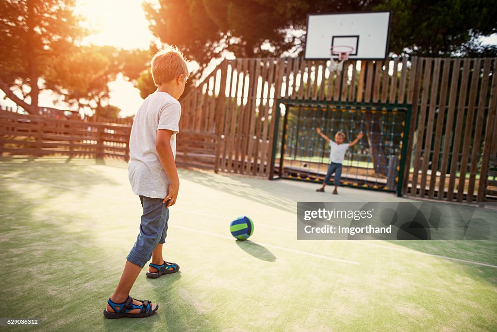 Kinder spielen Fußball auf dem Schulhof