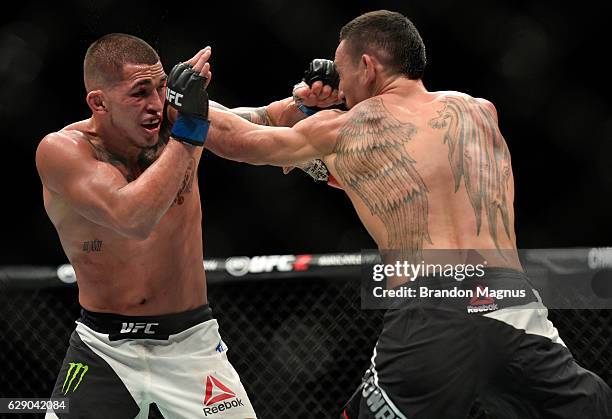 Max Holloway punches Anthony Pettis in their interim UFC featherweight championship bout during the UFC 206 event inside the Air Canada Centre on...