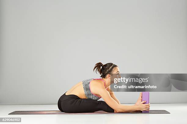 woman practicing advanced yoga pilates stretching training yoga block poses - yoga block stock pictures, royalty-free photos & images