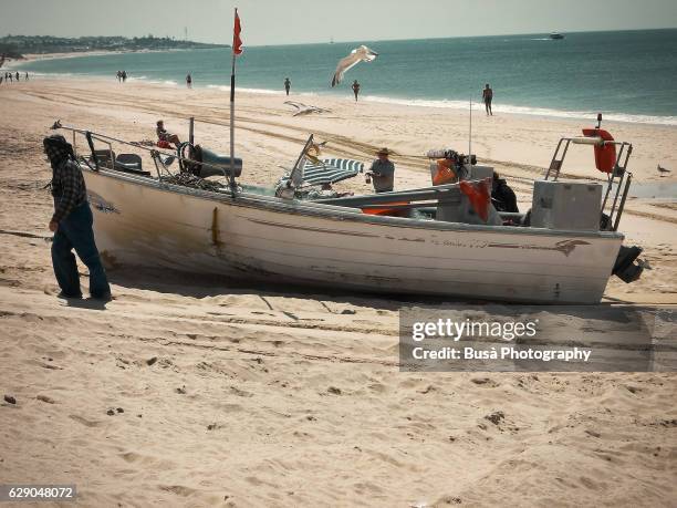 fisherman and fishing boats on the beach, armacao de pera, algavre, silves, portugal - armacao de pera algarve stockfoto's en -beelden