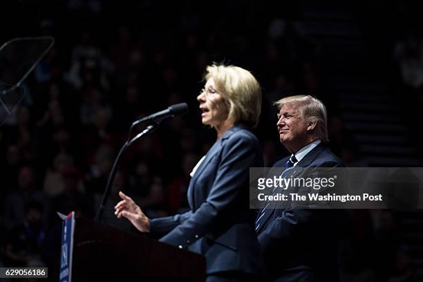 President-Elect Donald J. Trump listens as Betsy DeVos speaks at a "USA Thank You Tour 2016" event at the DeltaPlex in Grand Rapids, Mi. On Friday,...