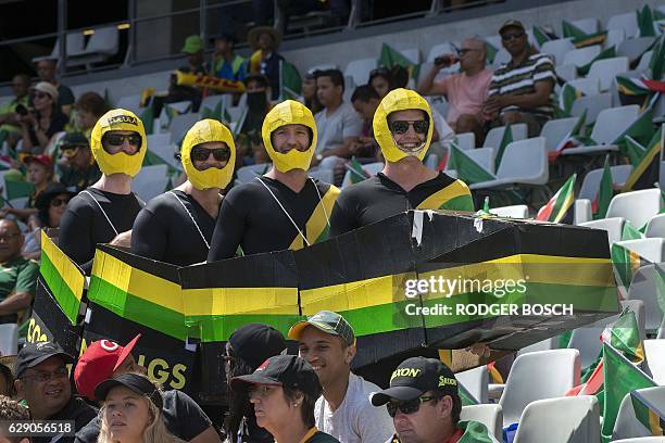 Members of the crowd dressed as a bobsleigh team attend the World Sevens Cape Town leg rugby match between Japan and Argentina at the Cape Town...
