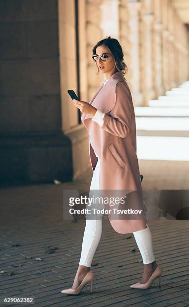 beautiful elegant woman texting outdoors - high heels stock pictures, royalty-free photos & images