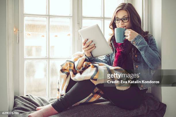 young woman at home - e reader stock pictures, royalty-free photos & images