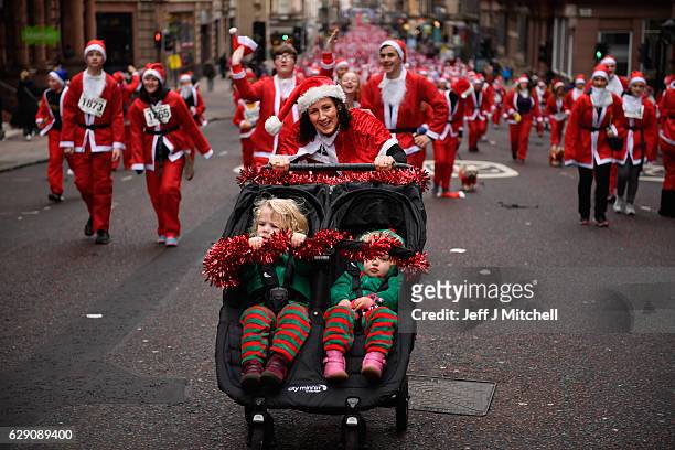 Over seven thousands of members of the public dressed as Santas make their way up St Vincent Street on December 11, 2016 in Glasgow, Scotland. The...