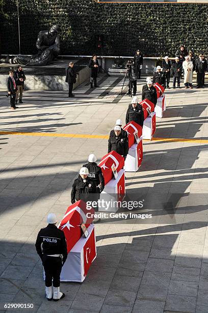 Turkish police officers stand guarded near the flag-draped coffins of police officers killed in yesterday's blast on December 11, 2016 in Istanbul,...