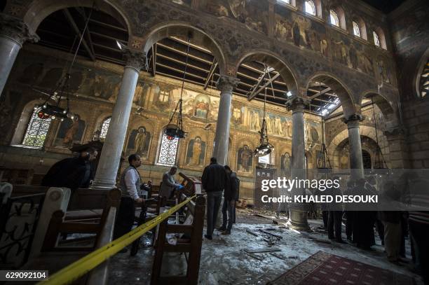 Egyptian security forces and officials inspect the scene of a bomb explosion at the Saint Peter and Saint Paul Coptic Orthodox Church on December 11...