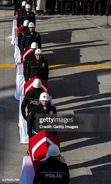 Turkish police officers stand guarded near the flag-draped coffins of police officers killed in yesterday's blast on December 11, 2016 in Istanbul,...