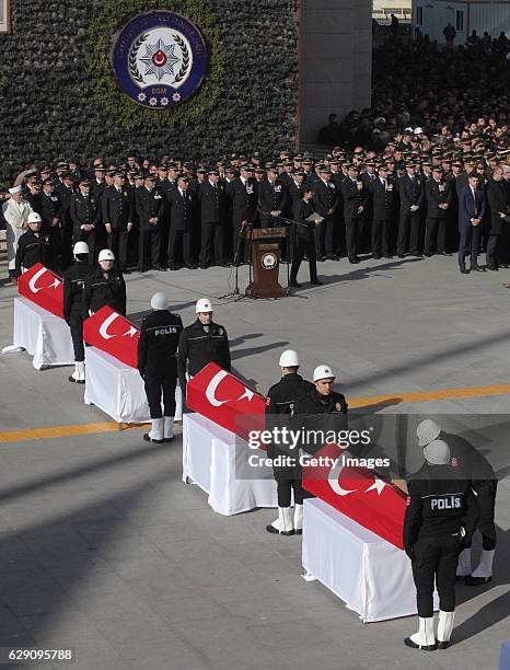 Turkish police officers stand guarded near the flag-draped coffins of police officers killed in yesterday's blast on December 11, 2016 in Istanbul,...