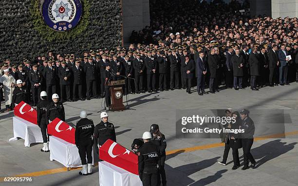 Turkish police officers stand guarded near the flag-draped coffins of police officers killed in yesterday's blast on December 11, 2016 in Istanbul,...