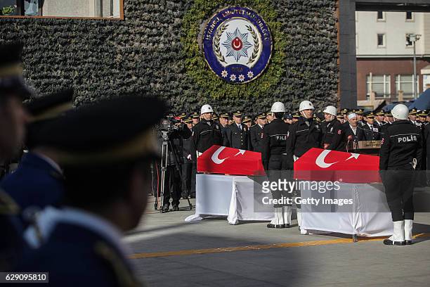 Turkish police officers stand guarded near the flag-draped coffins of police officers killed in yesterday's blast on December 11, 2016 in Istanbul,...