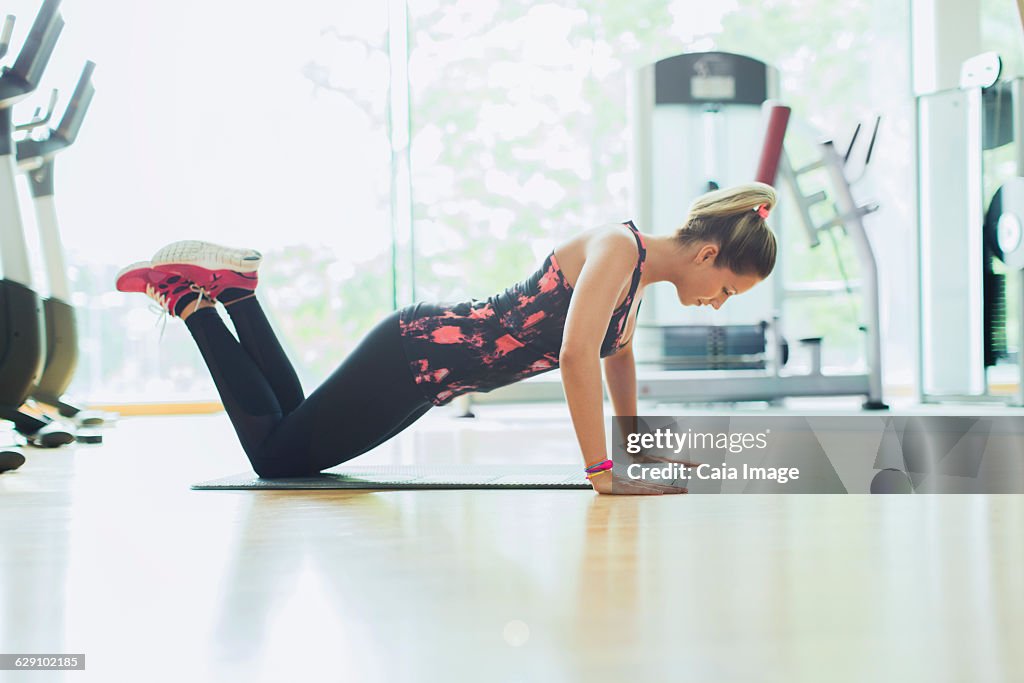 Woman doing push-ups on knees at gym